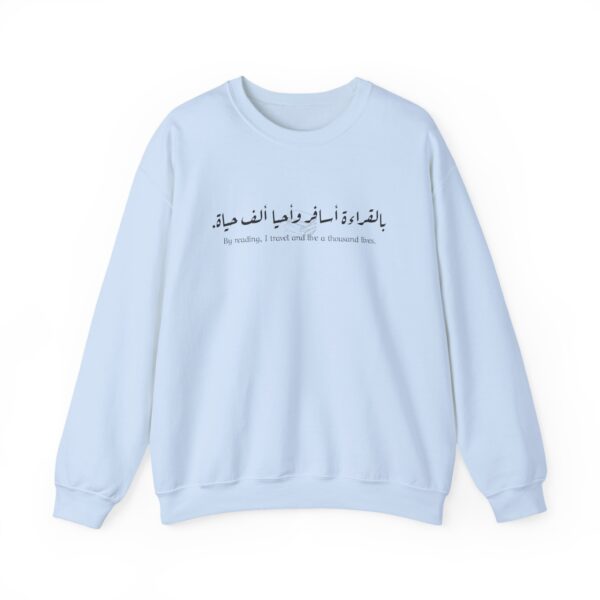 Book Lover Arabic sweatshirt with Arabic-English quote 'بالقراءة أسافر وأحيا ألف حياة' ('By reading, I travel and live a thousand lives') and stacked books illustration.