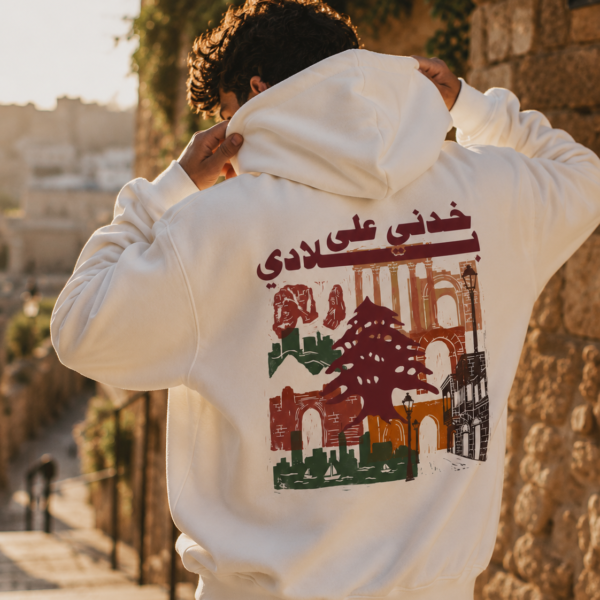 Man wearing white Lebanese Hoodie featuring "خدني على بلادي" vintage Lebanon graphic