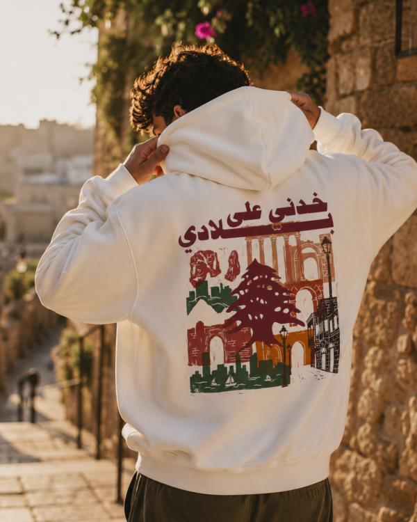 Man wearing white Lebanese Hoodie featuring "خدني على بلادي" vintage Lebanon graphic