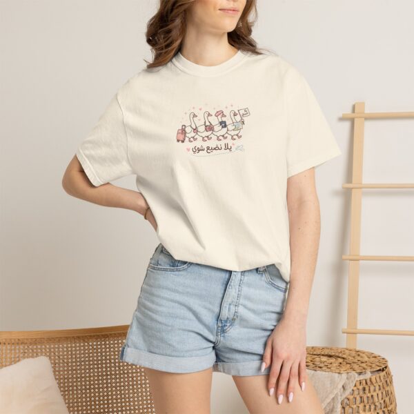 Woman wearing a cute Arabic travel t-shirt with the phrase "يلا نضيّع شوي" on Comfort Colors 1717 Ivory.